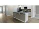 Bright kitchen featuring a central island, hardwood floors, and sleek white cabinets at 318 Bering Ln, Summerville, SC 29486