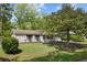 Charming single-story home with brick exterior, mature trees, and a well-manicured lawn at 323 Millcreek Dr, Charleston, SC 29407