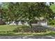 Charming single-story home with brick exterior, mature trees, and a well-manicured lawn at 323 Millcreek Dr, Charleston, SC 29407