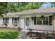 Charming brick home featuring a welcoming front door, manicured lawn and flower beds at 323 Millcreek Dr, Charleston, SC 29407