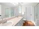 Bathroom with double vanity, walk-in shower, white subway tile and dark wood-look floor at 350 Arlington Dr, Charleston, SC 29414