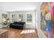 Sun-drenched living room with wood floors, stylish decor, and access to the backyard at 350 Arlington Dr, Charleston, SC 29414