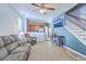 Open living area with wood-look tile, a gray sofa, access to the kitchen, and a staircase at 3661 Locklear Ln, Mount Pleasant, SC 29466