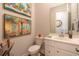 Compact bathroom with a single vanity, neutral colors, and colorful wall art at 397 Woodgate Way, Summerville, SC 29485