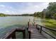 Wooden dock extending into a serene lake, offering picturesque waterfront access and stunning natural views at 397 Woodgate Way, Summerville, SC 29485