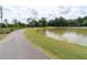 Picturesque lake view with a walking path, lush greenery, and serene atmosphere at 397 Woodgate Way, Summerville, SC 29485