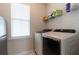 Well-lit laundry room with a modern washer and dryer set and ample shelving for storage solutions at 397 Woodgate Way, Summerville, SC 29485