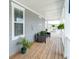 Inviting covered porch featuring comfortable seating, potted plants and ferns, and classic wood flooring at 397 Woodgate Way, Summerville, SC 29485