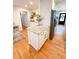 Granite kitchen island with seating, stainless fridge and hardware, and hardwood floors at 404 Rose Ln, Summerville, SC 29485