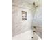 Close up of the shower featuring stunning marble-look tile, a built-in shower niche, and a handheld shower head at 404 Rose Ln, Summerville, SC 29485