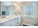 A brightly lit bathroom featuring double sinks with matching vanities under a large mirror and window at 419 Whispering Breeze Ln, Summerville, SC 29486
