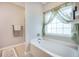 A relaxing bathtub with a large window and curtains allows natural light to fill the space at 419 Whispering Breeze Ln, Summerville, SC 29486