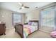 Cozy bedroom featuring a ceiling fan, a bed with colorful bedding, and natural light from the windows at 419 Whispering Breeze Ln, Summerville, SC 29486