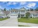 Charming two-story home with a well-manicured lawn, a two-car garage, and a welcoming front porch at 419 Whispering Breeze Ln, Summerville, SC 29486