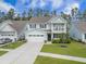 Charming two-story home featuring a front porch, well-manicured lawn, and a two-car garage at 419 Whispering Breeze Ln, Summerville, SC 29486