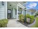 Inviting front porch area with rocking chairs, lush greenery, and a charming lantern post at 419 Whispering Breeze Ln, Summerville, SC 29486