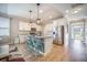 Open kitchen with white cabinets, stainless steel appliances, island with seating, and wood flooring at 419 Whispering Breeze Ln, Summerville, SC 29486