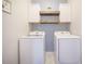 Well-organized laundry room with a washer, dryer, wooden shelves, and eye-catching wallpaper at 419 Whispering Breeze Ln, Summerville, SC 29486