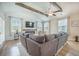 Bright living room boasts vaulted ceilings, wood beams, a fireplace, large sectional sofa, and plenty of windows at 419 Whispering Breeze Ln, Summerville, SC 29486