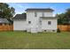 Back exterior view of a white two-story home, featuring a well-maintained lawn and wooden fence at 4301 Trevor St, North Charleston, SC 29420