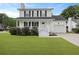 Charming two-story home featuring white siding, black shutters, a well-manicured lawn, and an attached garage at 4301 Trevor St, North Charleston, SC 29420