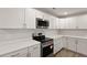 Bright kitchen boasts white cabinets, stainless steel appliances, and ample counter space at 4301 Trevor St, North Charleston, SC 29420