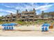 Beachfront property featuring multiple units with private balconies and beach access with seating and umbrellas at 4319 Sea Forest Dr, Kiawah Island, SC 29455