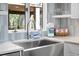 Bright kitchen with stainless steel sink, modern faucet, and open shelving with stylish decor at 4319 Sea Forest Dr, Kiawah Island, SC 29455