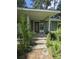 Close up of a front porch with concrete steps leading up to the front door in a home surrounded by overgrown foliage at 436 W Butternut Rd, Summerville, SC 29483