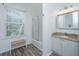 Bright bathroom features tub and shower with glass doors, vanity, and large window at 607 Jungle Rd, Edisto Beach, SC 29438