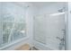 Bathroom features tiled tub and shower with glass doors, large window, and bench at 607 Jungle Rd, Edisto Beach, SC 29438