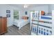 This bedroom features a twin bed, bunk beds, luxury vinyl floors, and ample natural light at 607 Jungle Rd, Edisto Beach, SC 29438