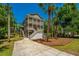 Exterior elevation featuring two stories, balconies, landscaping, and a long driveway at 607 Jungle Rd, Edisto Beach, SC 29438
