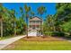 Charming two-story home surrounded by mature palm trees with a beautiful manicured yard at 607 Jungle Rd, Edisto Beach, SC 29438