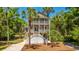 Charming two-story beach home with double porches, palm trees, and landscaped yard at 607 Jungle Rd, Edisto Beach, SC 29438