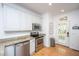 Bright kitchen features stainless steel appliances, granite countertops, white cabinets, and exterior door at 607 Jungle Rd, Edisto Beach, SC 29438