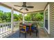 Charming covered porch featuring a table and chairs for outdoor dining and relaxation at 607 Jungle Rd, Edisto Beach, SC 29438