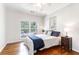 Bright bedroom with a ceiling fan, large window, hardwood floors, and side table at 700 Daniel Ellis Dr # 4107, Charleston, SC 29412
