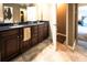 Bathroom featuring double vanity with dark wood cabinets and tiled floors with a view to the main bedroom at 8009 Indian Hill Dr, Hanahan, SC 29410