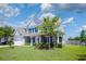 Inviting two-story home features a covered front porch, manicured lawn, and attached two-car garage at 8009 Indian Hill Dr, Hanahan, SC 29410