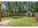 Spacious backyard featuring a well-maintained lawn, wood fence, and convenient storage shed at 8661 Laurel Grove Ln, North Charleston, SC 29420