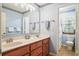 Bright bathroom features a double sink vanity, a large mirror, and a view of the toilet and shower at 8661 Laurel Grove Ln, North Charleston, SC 29420
