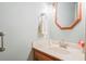 Light blue half bath with a wood-trimmed mirror, white towel, and countertop accents at 8661 Laurel Grove Ln, North Charleston, SC 29420