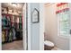 Walk-in closet with clothing racks and storage shelves, next to a charming half-bath at 8661 Laurel Grove Ln, North Charleston, SC 29420