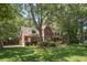 Traditional brick home surrounded by mature trees, landscaping and a lush green lawn at 8661 Laurel Grove Ln, North Charleston, SC 29420