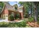 Traditional brick home with a side-entry garage, lush landscaping, and a well-manicured lawn at 8661 Laurel Grove Ln, North Charleston, SC 29420