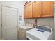 Laundry room featuring a white washer and dryer, along with storage cabinets, and a laundry themed wall decoration at 8661 Laurel Grove Ln, North Charleston, SC 29420