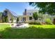 Backyard view with patio, lush lawn, seating area, outbuilding, and mature trees at 1001 Foxcroft Rd, James Island, SC 29412