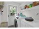 Bright laundry room with white shiplap, modern appliances, and ample storage shelves at 1001 Foxcroft Rd, James Island, SC 29412