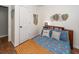 View of a bedroom features neutral walls, a bed with a bookcase headboard, and a leaf wall hanging at 104 Clover St, Summerville, SC 29483